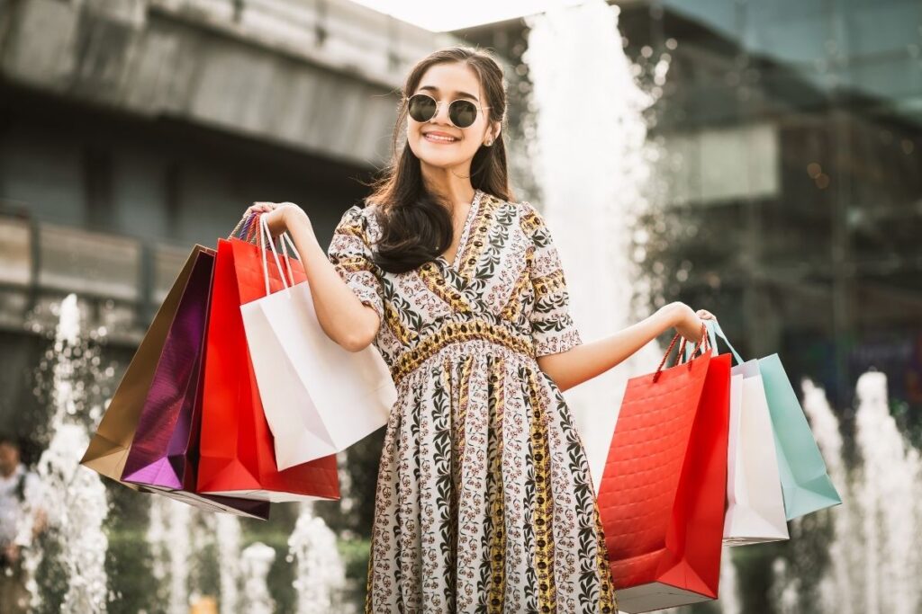 Woman shopping in Bangkok holding red bags