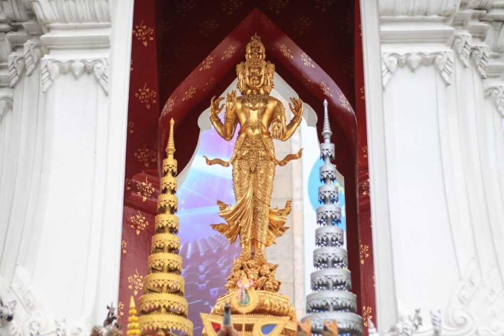 Golden Trimurti Shrine at Ratchaprasong in Bangkok, decorated with offerings